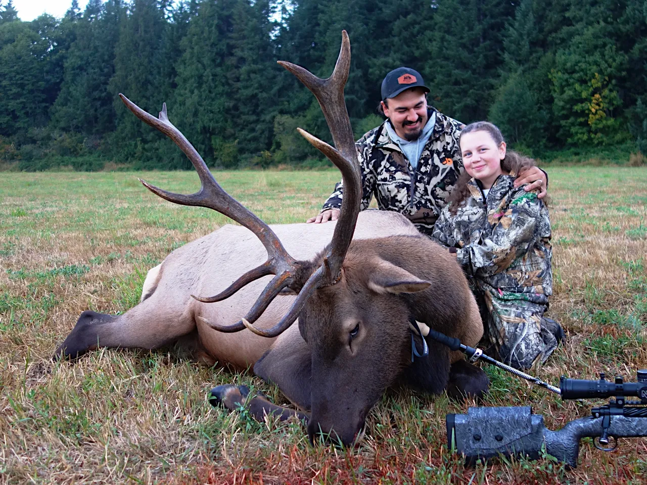 Hunters posing with a large harvested elk.