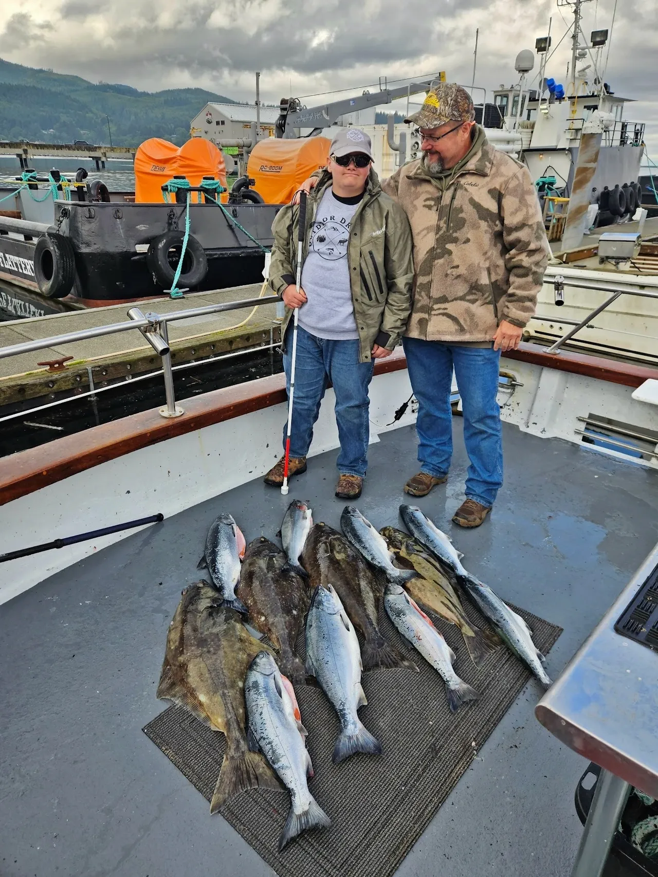 Two people with freshly caught fish on boat.