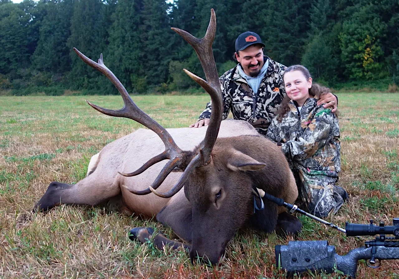 Hunters posing with a large harvested elk.