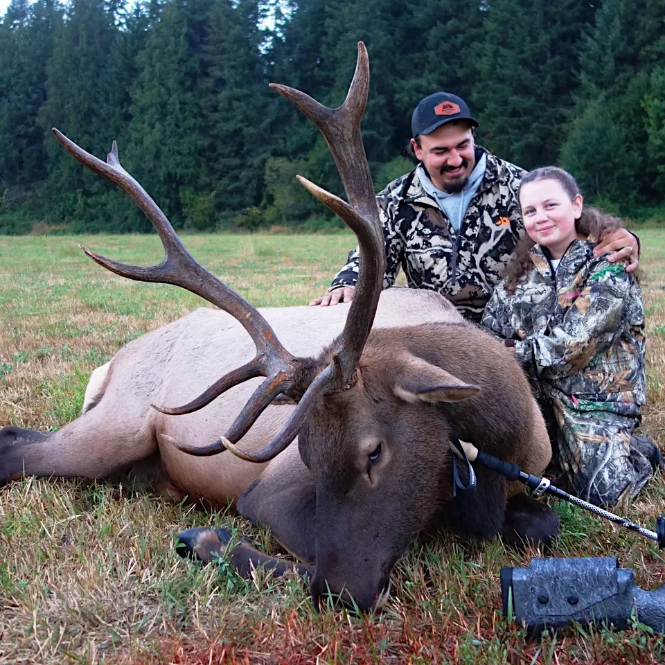 Hunters posing with a large harvested elk.