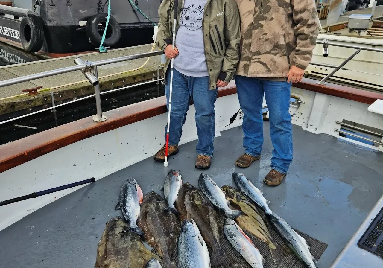 Two people with freshly caught fish on boat.