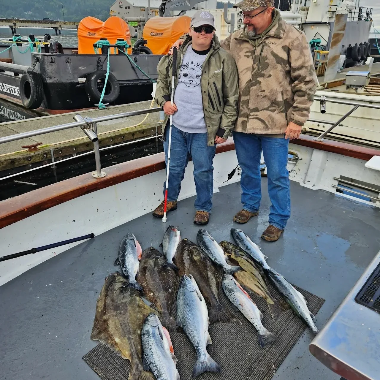 Two people with freshly caught fish on boat.
