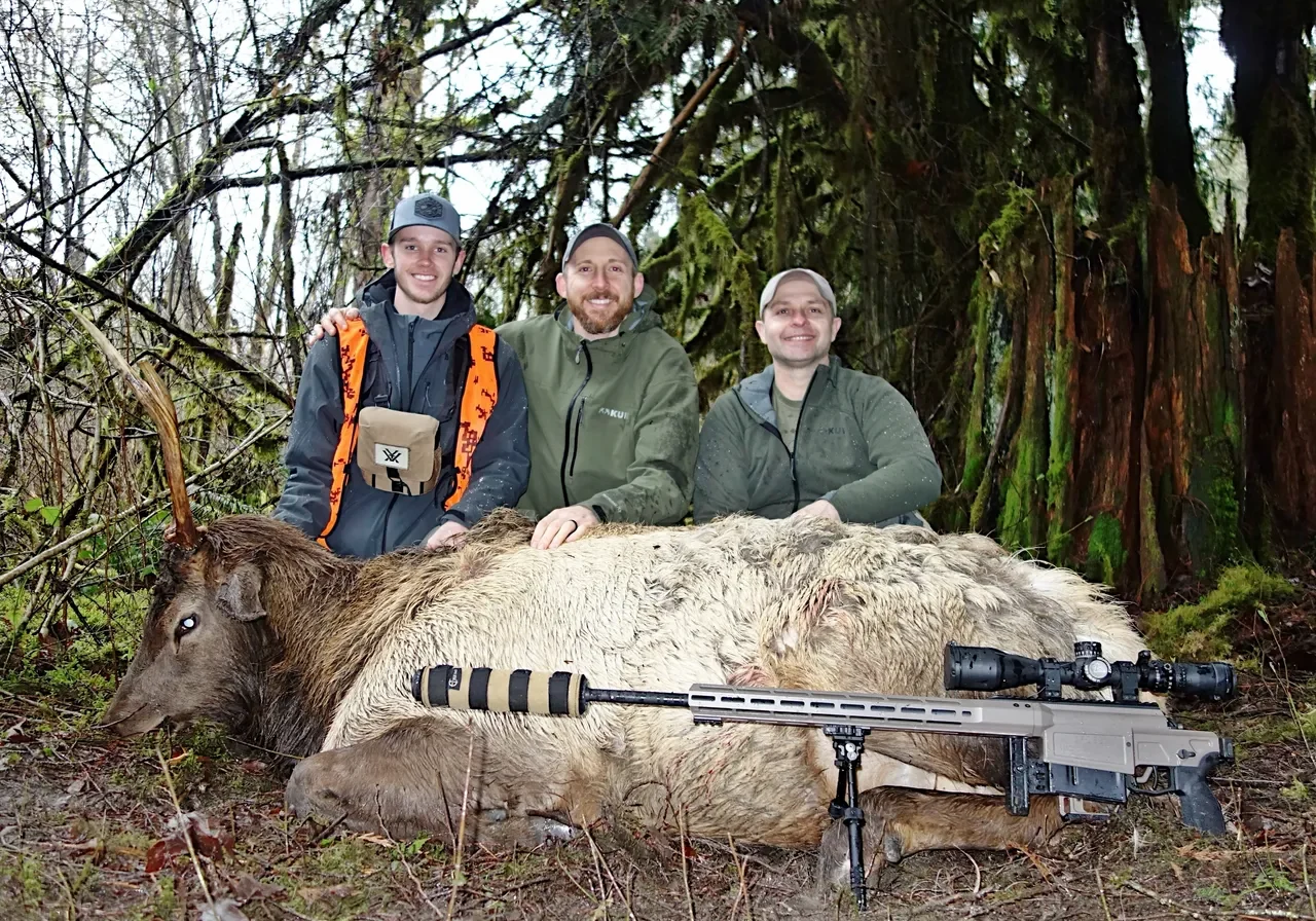 Three hunters posing with harvested elk.
